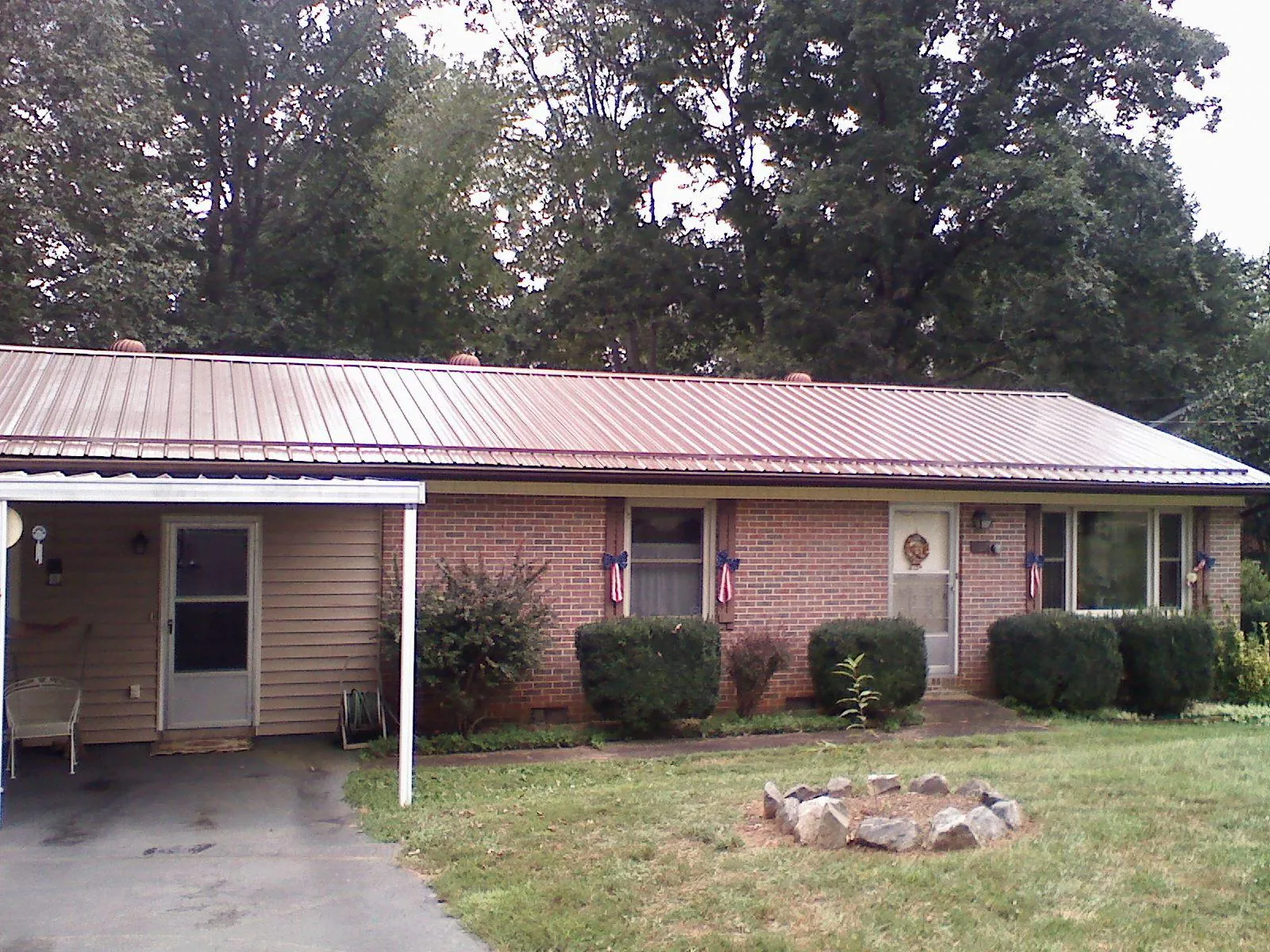 Bronze metal roof and carport on a brick ranch home — Roof Repair work by our crew in Newton Lower Falls